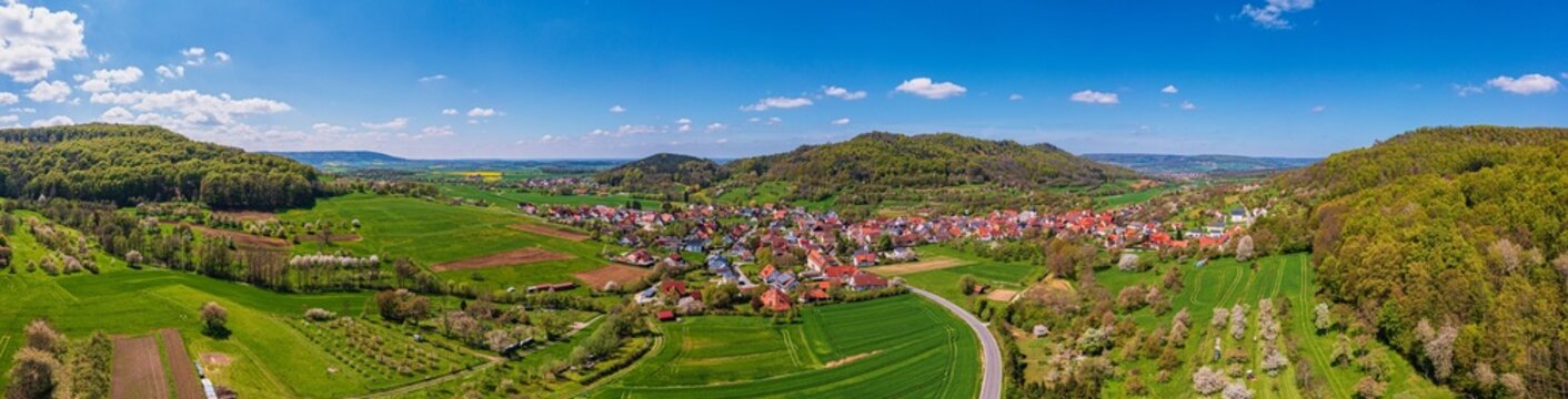 Spring landscape from above in Franconian Switzerland with a village and the Walberla mountain in the background