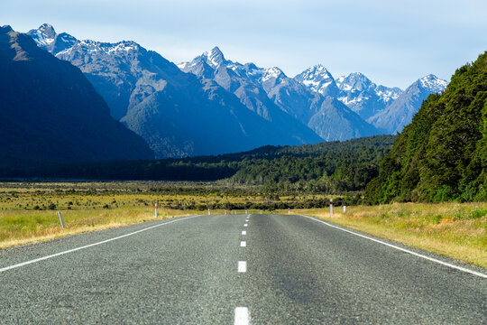 Low angle of bitumen road towards snow-capped mountains