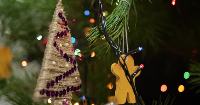 Close up of Handmade Christmas Decorations Hanging on Live Potted Aromatic Fir Tree with Sequined Ornament Knitted Snowflakes Dried Pine Cones and Live Root System for Sustainable Holiday Celebration