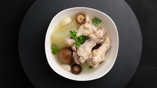 Winter Melon with Chicken wings (drumettes) and preserved lime soup in white bowl.Thai food.Top view.