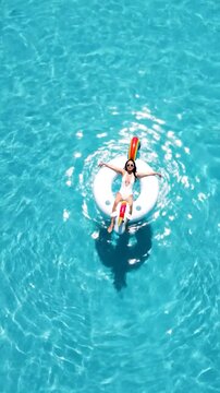 Woman relaxing on a unicorn float in a bright blue swimming pool
