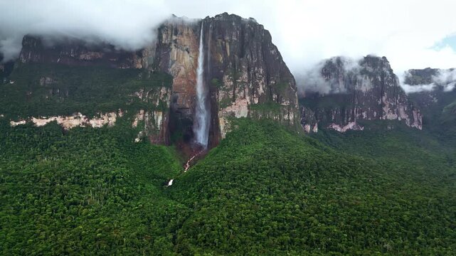 Aerial drone view of Angel Falls flowing down the cliffs of Auyan-tepui with clouds drifting across the mountains in Canaima National Park, Venezuela