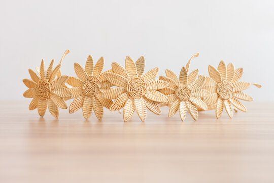 Flowers are made of straw on a white background. Straw weaving. Small depth of field.
