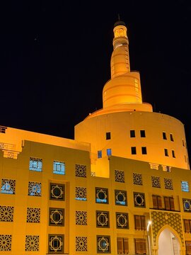 Fanar Islamic Cultural Center spiral mosque tower in Doha at night. Illuminated spiral tower of Fanar Islamic Cultural Center mosque in Doha Qatar at night.