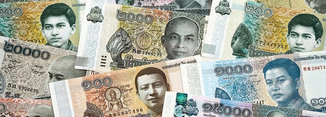 Cambodian riel money bills pile on table. Cambodia banknotes of KHR currency close up. Concept of business, economy and banking in Cambodia © mehaniq41