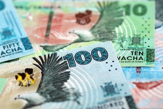 Zambian kwacha money bills pile on table. Zambia banknotes of ZMW currency close up. Concept of business, economy and banking in Zambia