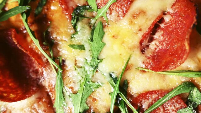 Pepperoni pizza texture with fresh arugula, top view Italian cuisine background