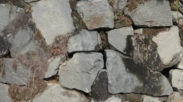 Broken stone pavement with deep cracks, damaged rough surface texture