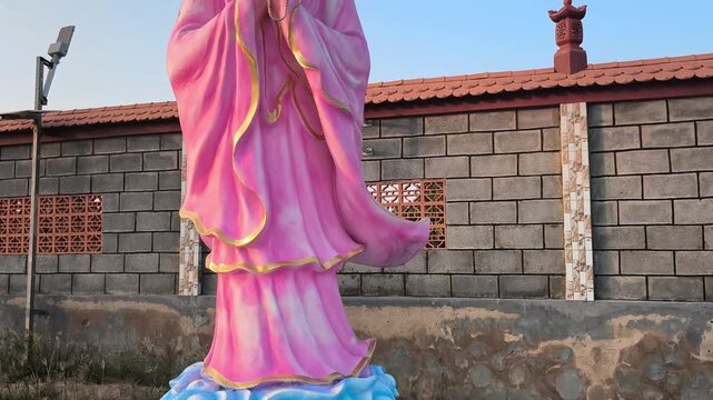 Small Pink Guanyin Bodhisattva Statue in peaceful garden - 4K 16:9