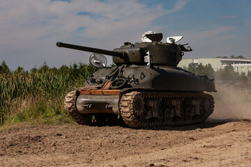 Fototapeta premium An American World War II Sherman tank drives across a field.