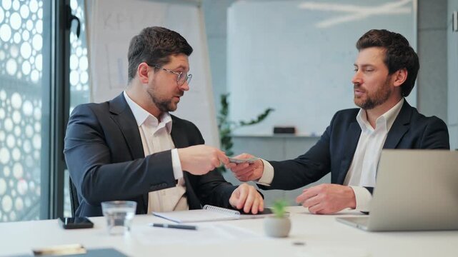 Adult people meeting concludes with successful business transaction. Money exchanges hands, followed by confident handshake. Demonstrates trust, satisfaction strong partnership financial achievement.