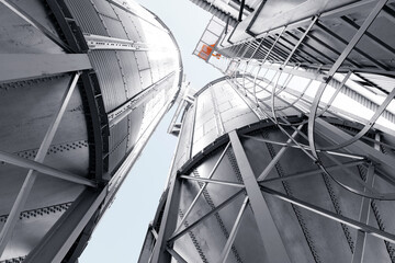 Fototapeta na wymiar Industrial silos with steel framework and skyward perspective