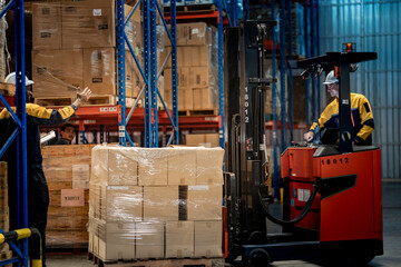 Caucasian male factory employee driving heavy forklift vehicle with wrapped cargo boxes. Diverse logistics teamwork managing safe freight transport and commercial distribution operations. © ultramansk