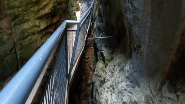 Pasarelas met&aacute;licas del desfiladero de Desfiladero de La Yecla, un espectacular ca&ntilde;&oacute;n natural rodeado de altas paredes rocosas. La escena muestra el recorrido a trav&eacute;s de estrechos pasillos suspendido