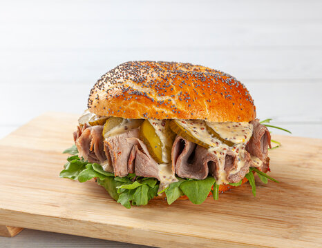 Delicious bagel with roast beef, pickles, and arugula.