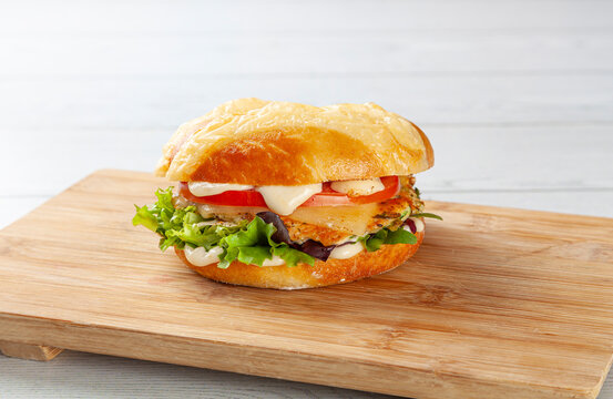 Delicious chicken and cheese bagel with tomato and lettuce.