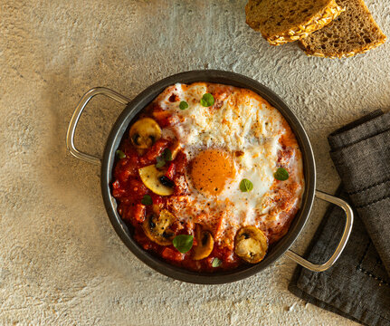 Casserole with egg, mushrooms, fried tomato, and oregano