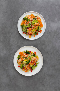 Two plates of rice with vegetables and shrimp, oriental food