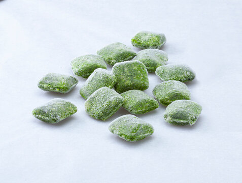 Blocks of frozen vegetables on a white background
