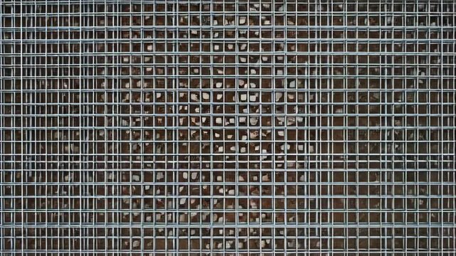 Metallic wire mesh fence surface texture. Industrial grid pattern background. Stainless steel weave for construction and security screen detail, macro view display.