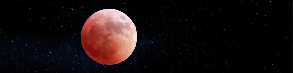 Fototapeta premium Red tinted moon rising beside scattered stars in dark sky