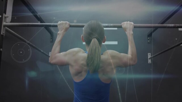 Female athlete pulling on pull-up bar from dead hang during training, lens flares highlighting back