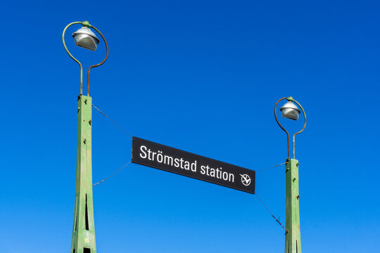 Stromstad, Sweden - September 21, 2019: Railway Station Entrance Sign in Sweden with Vasttrafik Logo on Vintage Green Lampposts under Clear Blue Sky