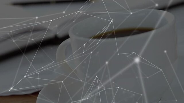 Camera panning, centering coffee cup while tech net mesh linking cup and notebook, showing link