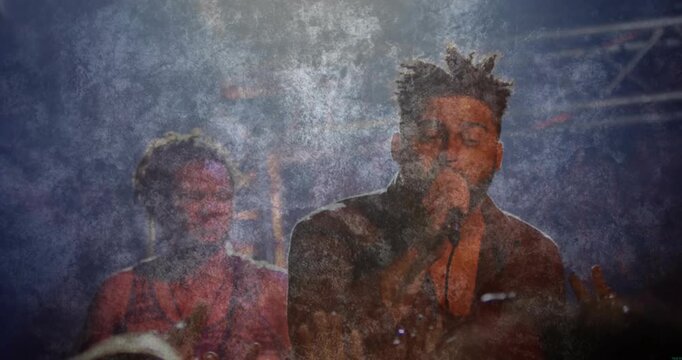 Male lead singer starting song by singing into mic, backing musician keeping beat, overlay pulsing