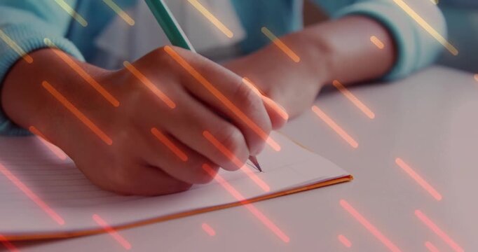 Pupil hand touching notebook with green pencil drawing for school as orange streaks occluding hand