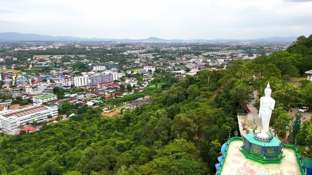 SI RACHA, THAILAND - MARCH 17, 2026: Aerial view of Samnaksong Khao Phra Khru Buddhist temple and monastery located on a hilltop overlooking the city.