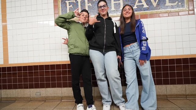 Children taking a photo together in Fifth Avenue subway station New York City