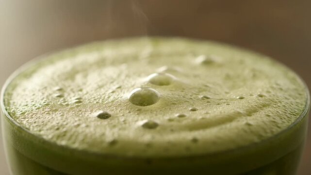 Close up of a delicious pistachio latte showing rich frothy creamy foam and rising steam