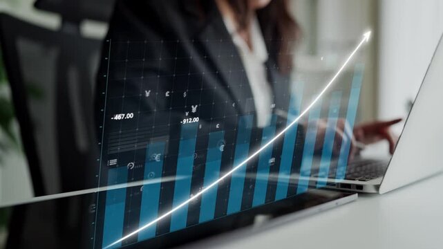 A business professional examines financial data on a laptop, highlighting growth trends with a digital graph in a contemporary office environment. Copula