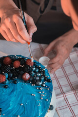 Obraz premium Hand painting edible dust on berry cake