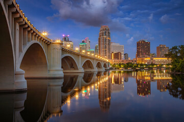 Minneapolis, Minnesota, USA. Cityscape image of downtown Minneapolis, Minnesota, USA with reflection of the city skyline in Mississippi River at twilight blue hour.