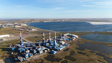 Oil drilling rigs and industrial facilities on prudhoe bay tundra beside icy bay waters, aerial view of north slope oil field and infrastructure amid arctic landscape, Alaska, US © Salah Latreche