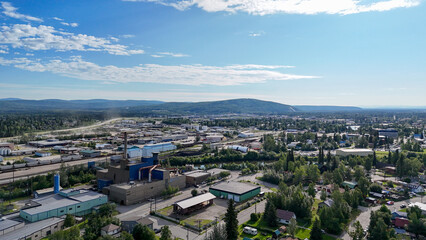 Obraz premium Fairbanks, alaska, displaying an aerial view of the cityscape with an industrial complex, railroad tracks, and quiet residential areas against a backdrop of distant mountains