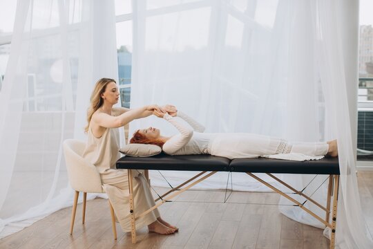 Practitioner performing theta healing session on woman