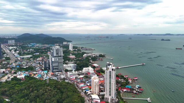 Drone flying over the urban landscape and coastal cityscape of Si Racha, Gulf of Thailand.