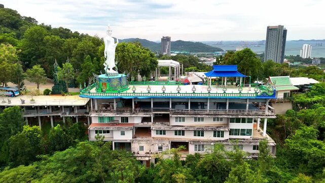 SI RACHA, THAILAND - MARCH 17, 2026: Aerial view of Samnaksong Khao Phra Khru Buddhist temple and monastery located on a hilltop overlooking the city.