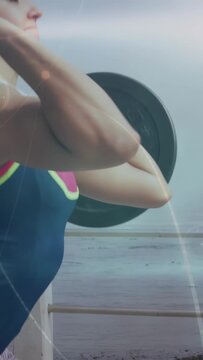 Woman lifter starting lift gripping bar and hinging hips, pulling into overhead lockout for fitness