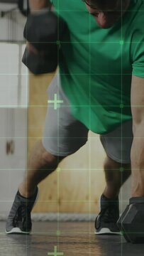 Vertical video: Man starting plank on weights, lowering and rowing for fitness, green grid tracking