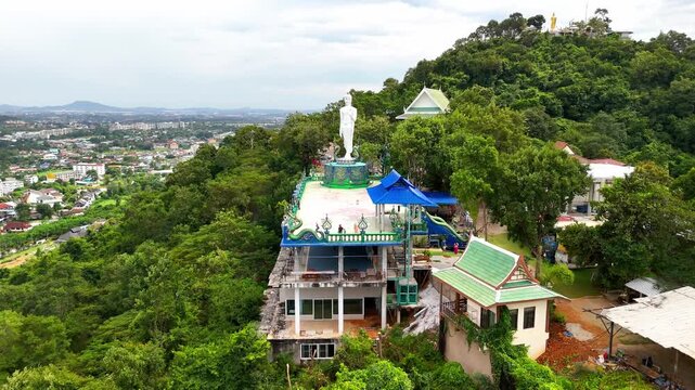 SI RACHA, THAILAND - MARCH 17, 2026: Aerial view of Samnaksong Khao Phra Khru Buddhist temple and monastery located on a hilltop overlooking the city.