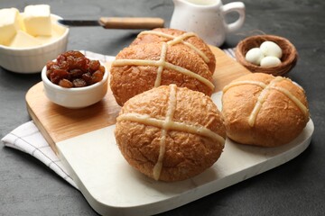 Fototapeta premium Delicious hot cross buns served on dark textured table, closeup