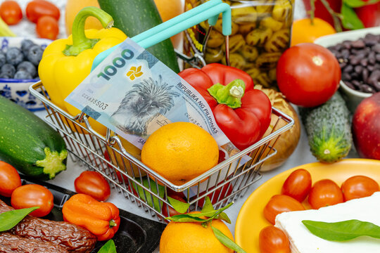 Shopping cart with food and Philippinian money. Financial and business concept. Rising prices in Philippines, increasing food prices. Close up