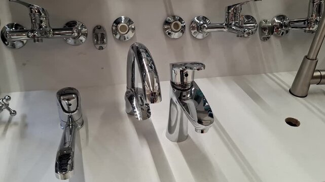 Wide variety of modern chrome faucets and mixers in retail. Polished metallic surfaces, for different designs for bathroom and kitchen. Plumbing fixtures and water taps for modern home or hotel