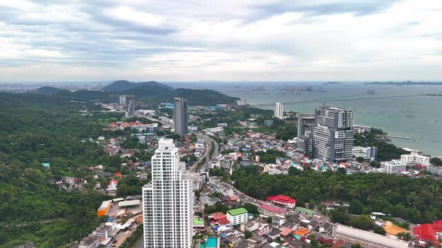 Drone flying over the urban landscape and coastal cityscape of Si Racha, Gulf of Thailand.