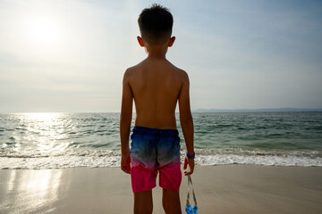 Profile portrait of a young boy looking at the sea on a sunny beach in Puerto Vallarta © alejandro