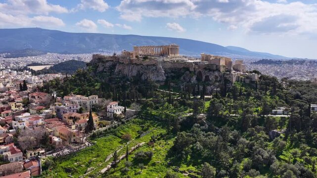 Aerial drone cinematic video above ancient Agora featuring Acropolis hill and the Parthenon, Athens historic centre, Attica, Greece